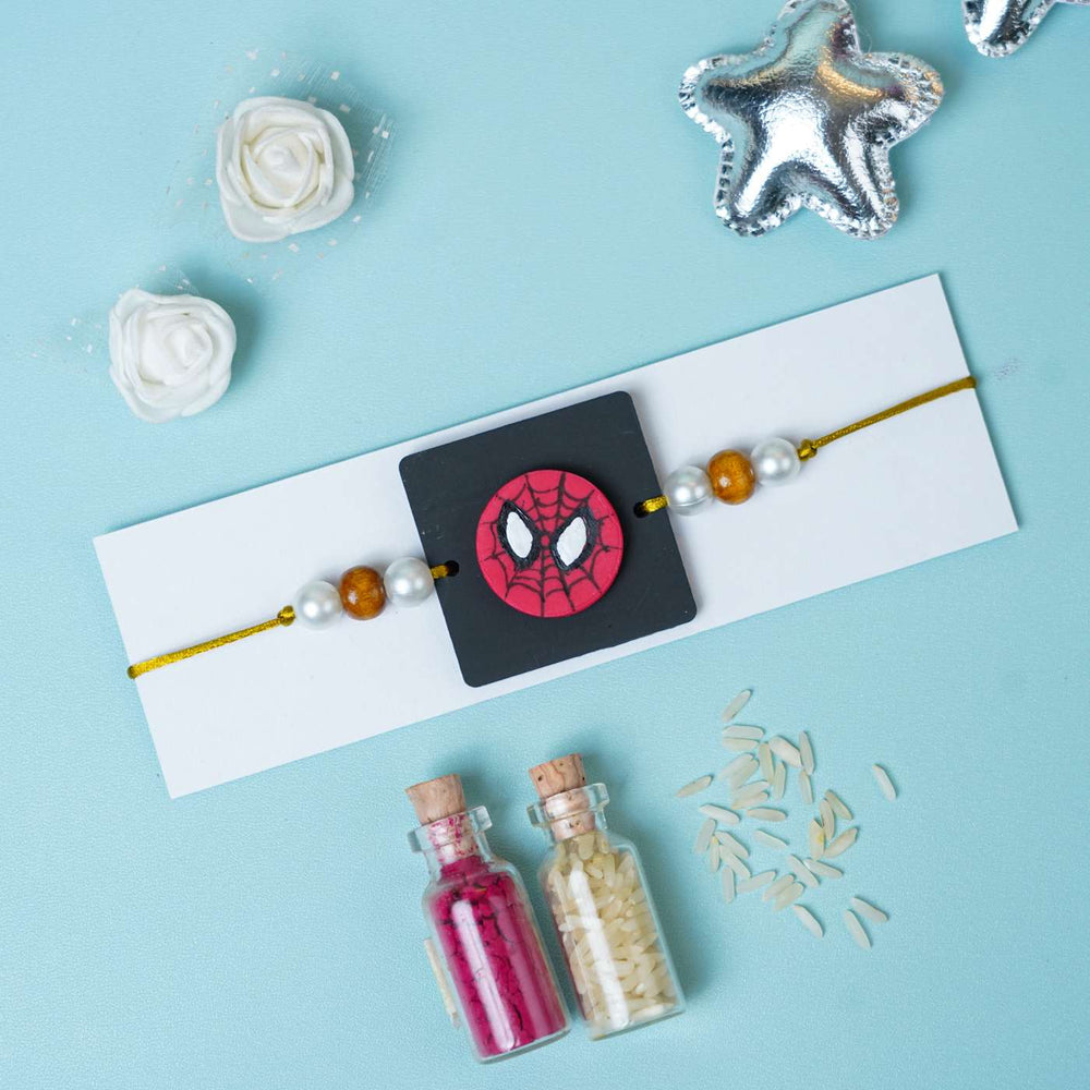 Handmade Miniature Clay Spiderman Kids Rakhi With Roli Chawal - Flat lay with gift items