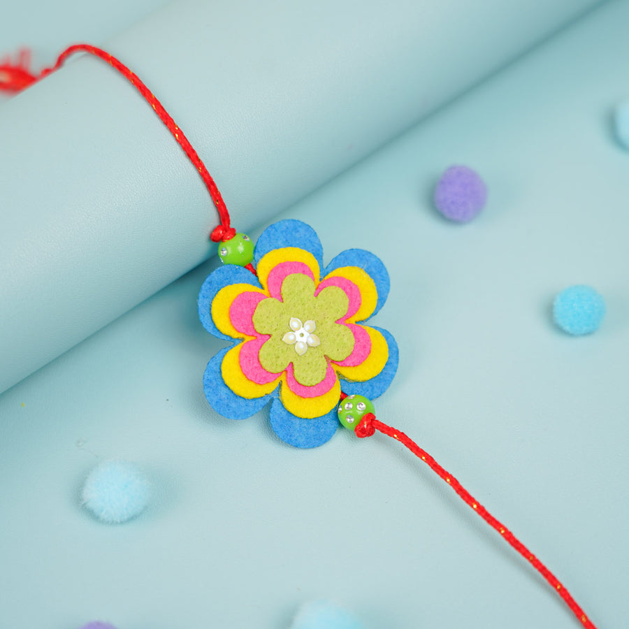 Handmade Beaded Flower Theme Pom Pom Felt Rakhi With Roli Chawal For Kids - Close-up Front View