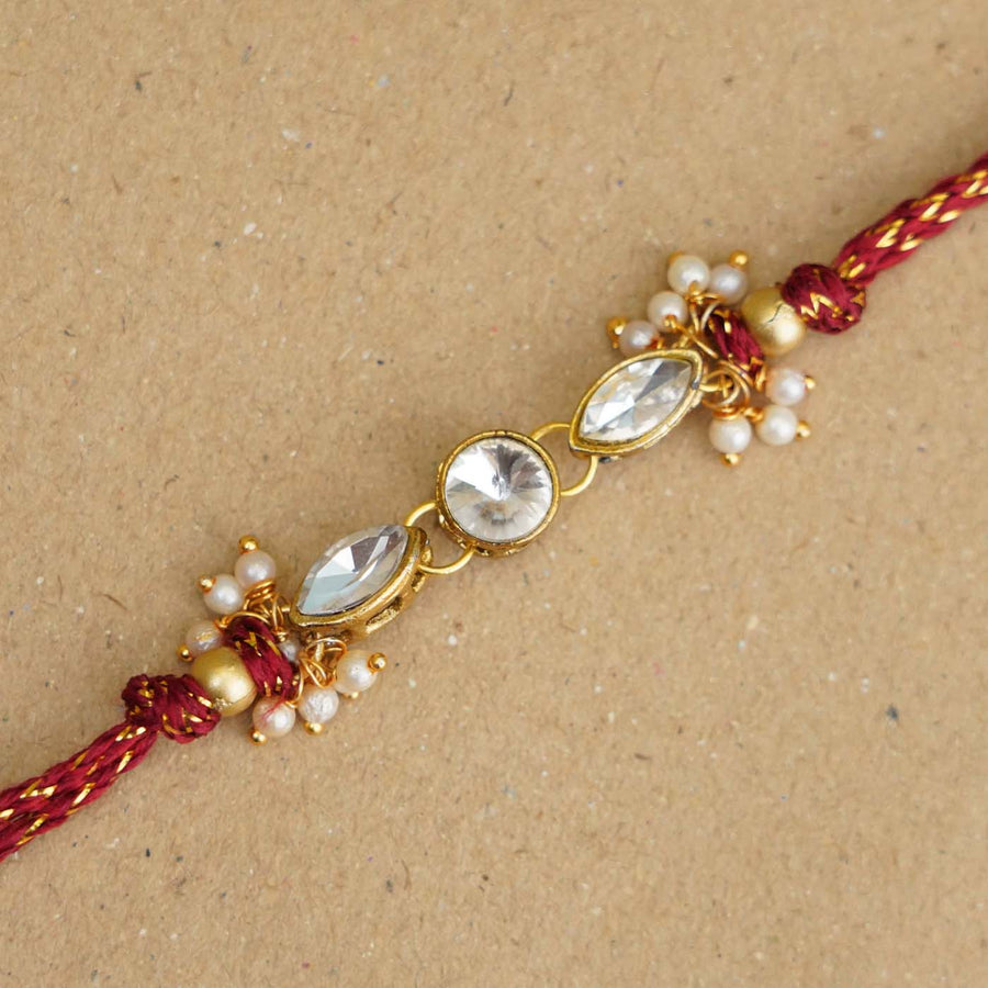 Handmade White Kundan Pearl Rakhi With Roli Chawal - Close-up of Rakhi decor