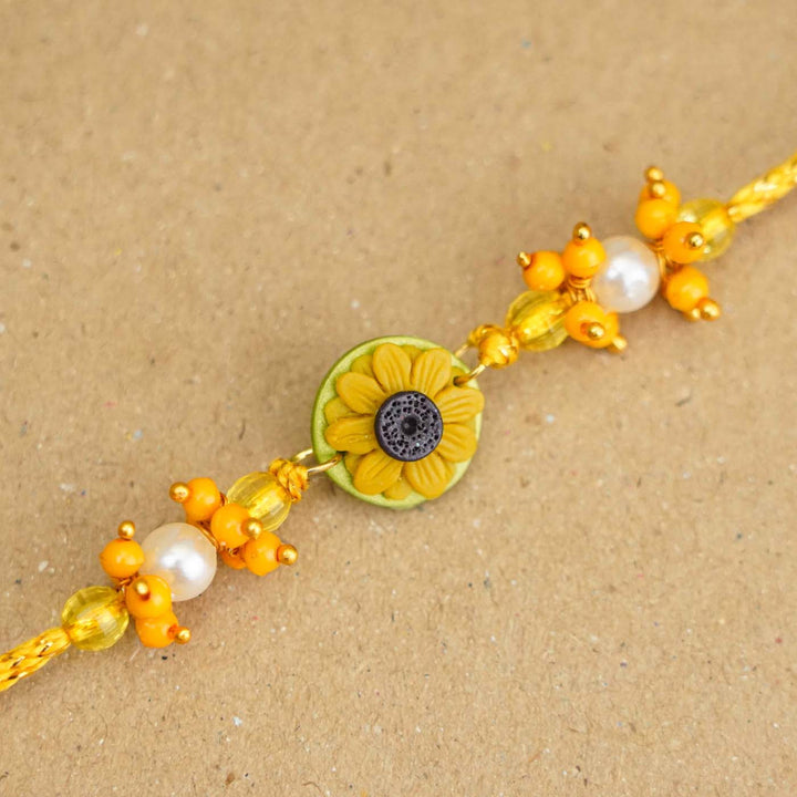 Handmade Miniature Clay Sunflower Rakhi With Roli Chawal - Close-up of Bracelet Detail