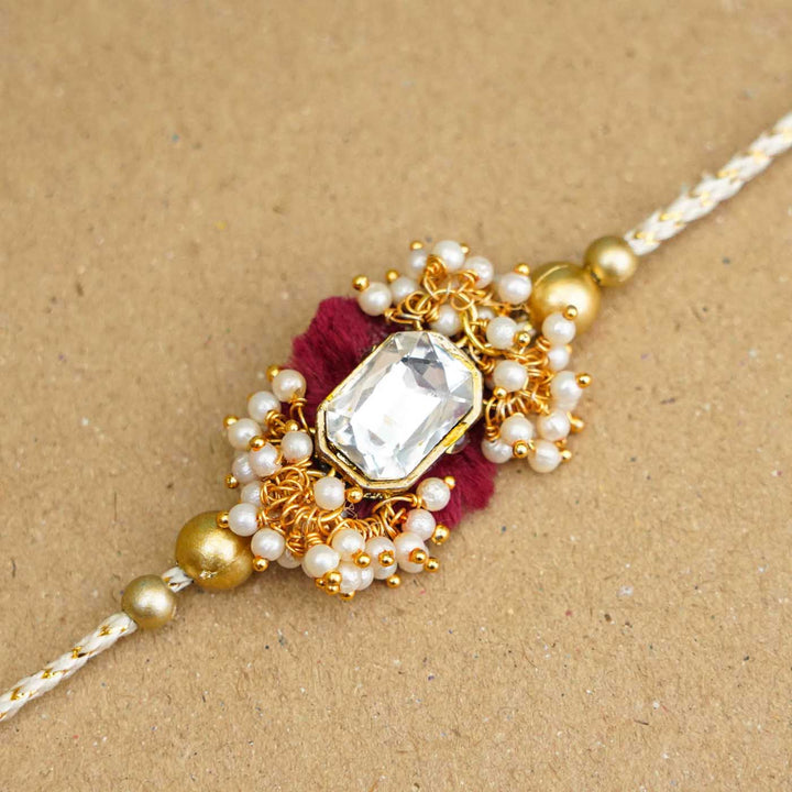 Handmade Large Kundan Stone Pearl Rakhi With Roli Chawal - Close-up of Rakhi centerpiece