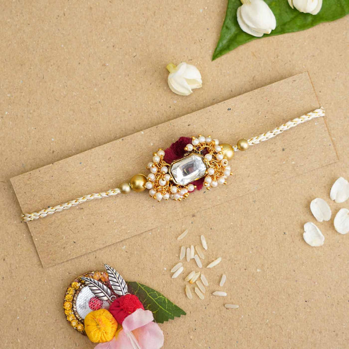 Handmade Large Kundan Stone Pearl Rakhi With Roli Chawal - Rakhi displayed on cardboard backing