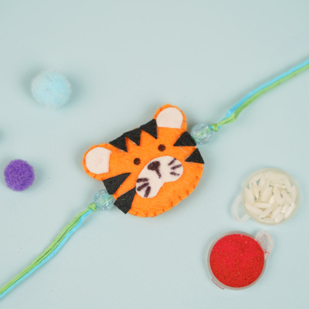 Handmade Tiger Theme Felt Kids Rakhi - Flat Lay with Festival Items