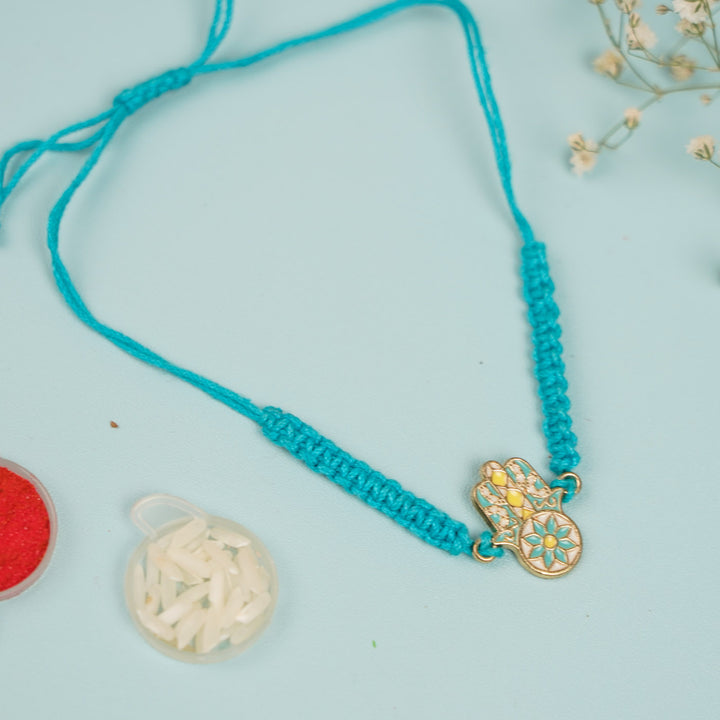 Handmade Hamsa Hand Design Metal Rakhi For Brother - Flat Lay with Decorative Elements