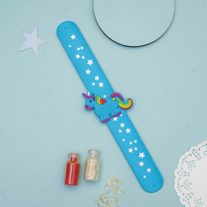 Handmade Unicorn Slap Band Kids Rakhi With Roli Chawal - Flat Lay with Decorative Items