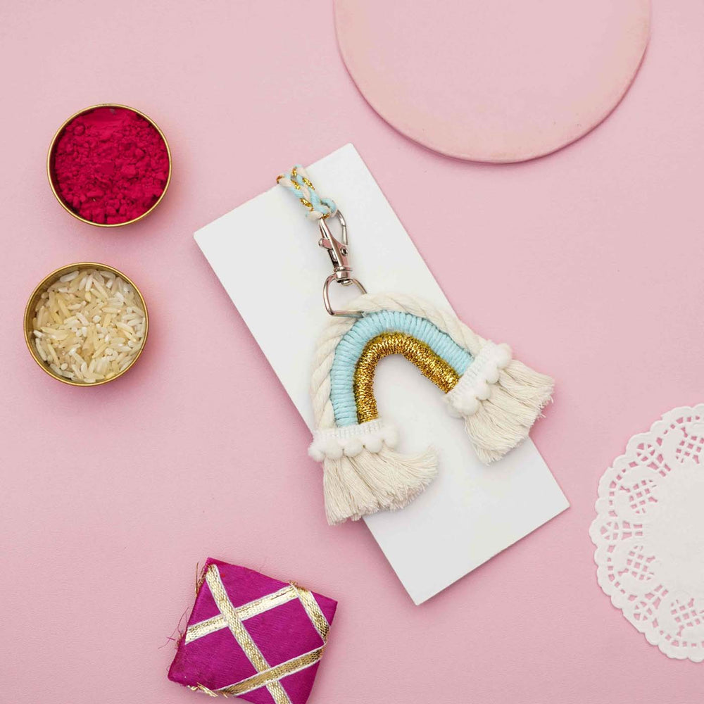 Handmade Macrame Rainbow Theme Cotton Kids Rakhi For Girls With Chocolates And Roli Chawal - Styled flat lay with accessories