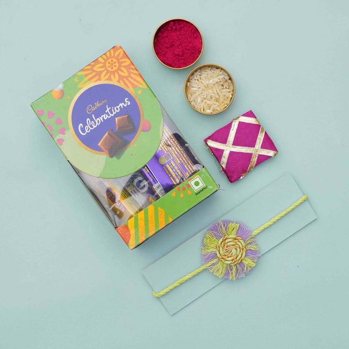 Handmade Macrame Purple And Green Cotton Rakhi With Chocolates And Roli Chawal - Flat lay with rakhi and gift box