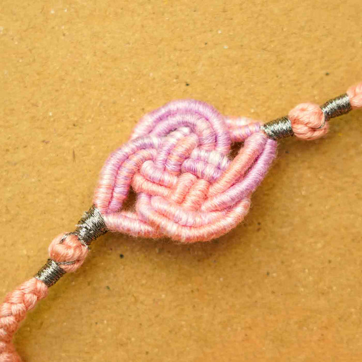 Reusable Embroidered Pink Ombre Infinity Knot Rakhi With Roli Chawal - Close-up of Threaded Centerpiece