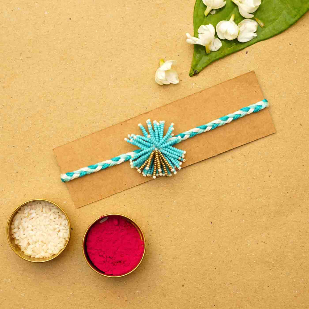 Reusable Beaded Blue Flower Rakhi With Roli Chawal - Product Display with Rakhi Ingredients