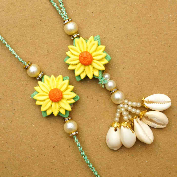 Handmade Yellow Flower Clay Bhaiya Bhabhi Rakhi With Chocolates And Roli Chawal Set Of 2 - Close-up of two Rakhis