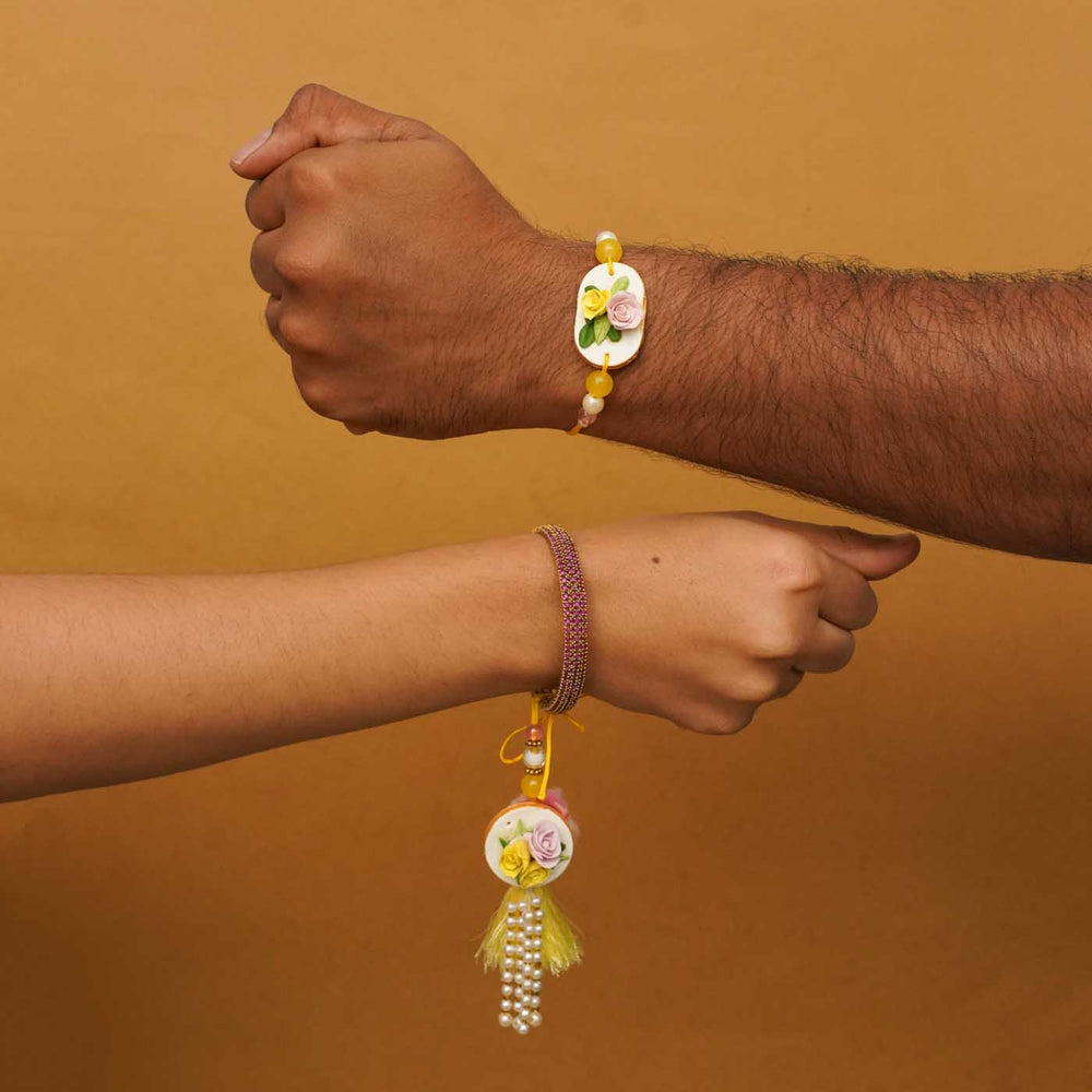 Handmade Rose Clay Bhaiya Bhabhi Rakhi With Chocolates And Roli Chawal Set Of 2 - On Wrists Close-up