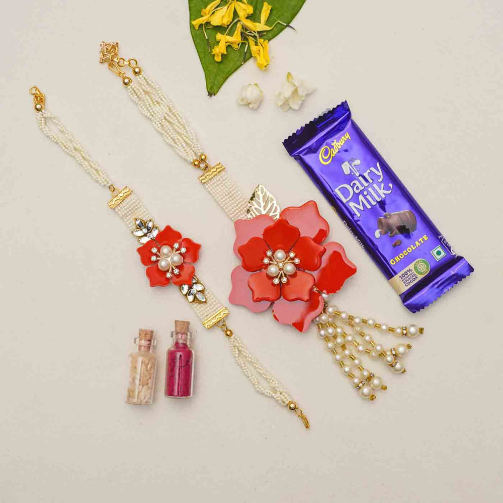 Handmade Red Flower Theme Resin Bhaiya Bhabhi Rakhi With Chocolates And Roli Chawal For Bhaiya And Bhabhi Set Of 2 - Flat Lay with Chocolate and Colors