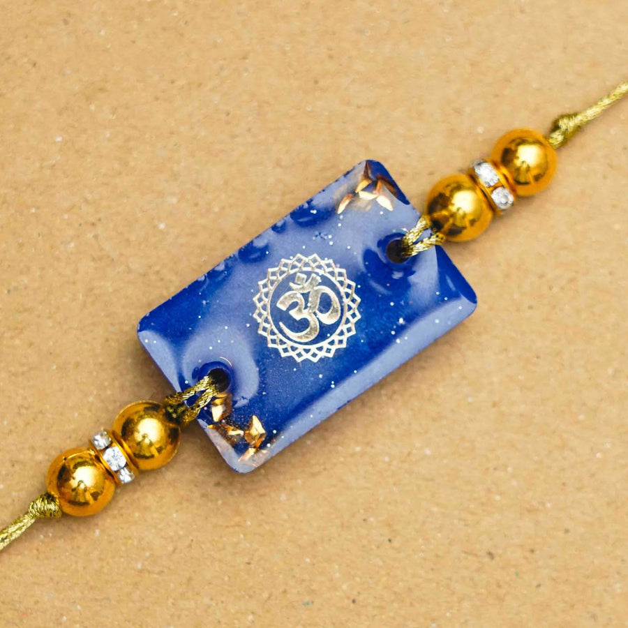 Handmade Resin Blue Om Rakhi With Roli Chawal - Close-up of pendant detail