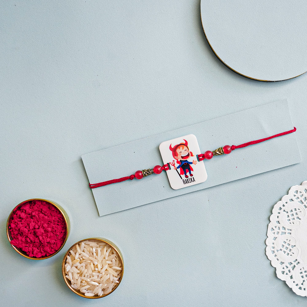 Personalized Handmade Devil Sister Acrylic Rakhi With Roli Chawal - Flat Lay with Colorful Powders