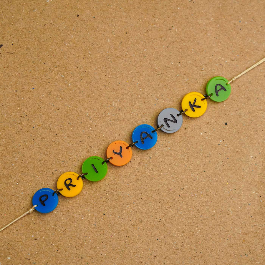 Personalized Handmade Gems Acrylic Rakhi With Roli Chawal - Close-up of name beads on string