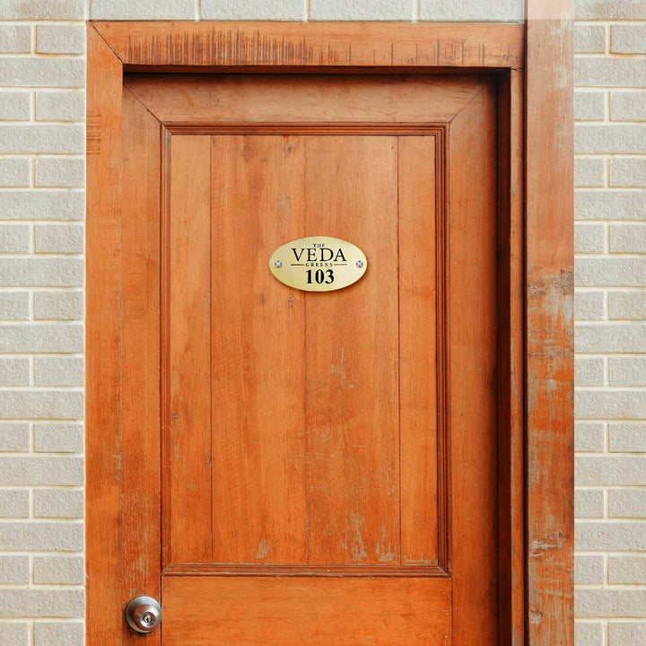 Personalized Waterproof Oval Golden Metal Name Plate - Mounted on Wooden Door Front View