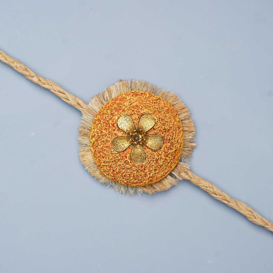 Handmade Papier Mache Antic Orange And Gold Floral Rakhi With Roli Chawal - Close-up View