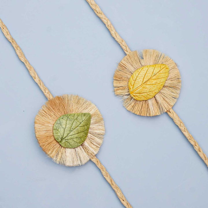 Handmade Papier Mache Yellow And Green Leaf Rakhi With Roli Chawal Set Of 2 - Close-up of two bracelets
