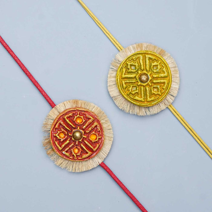 Handmade Papier Mache Red And Yellow Swastika Rakhi With Roli Chawal Set Of 2 - Close-up of two bracelets