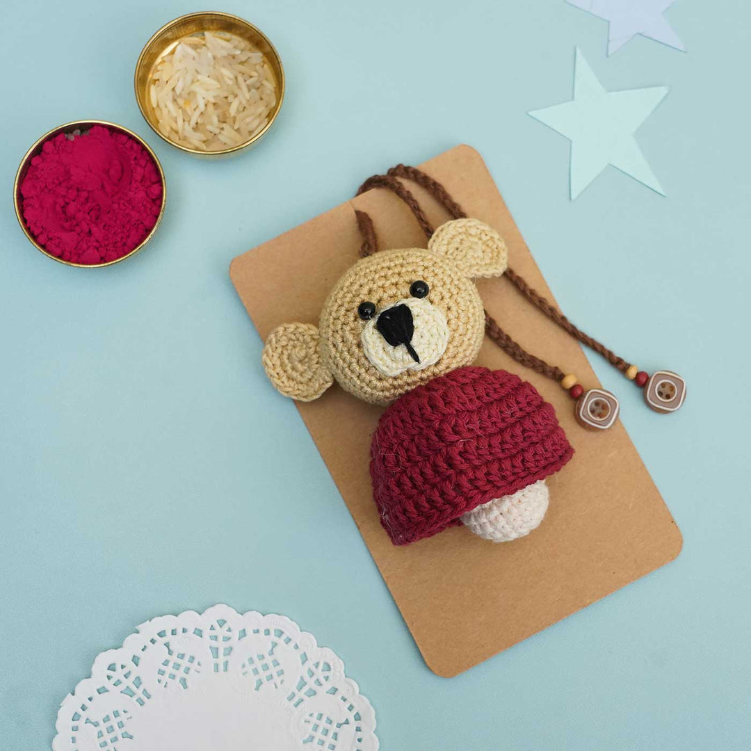 Handmade Crochet Teddy Hug Kids Rakhi With Roli Chawal - Close-up Front View with Red Cap