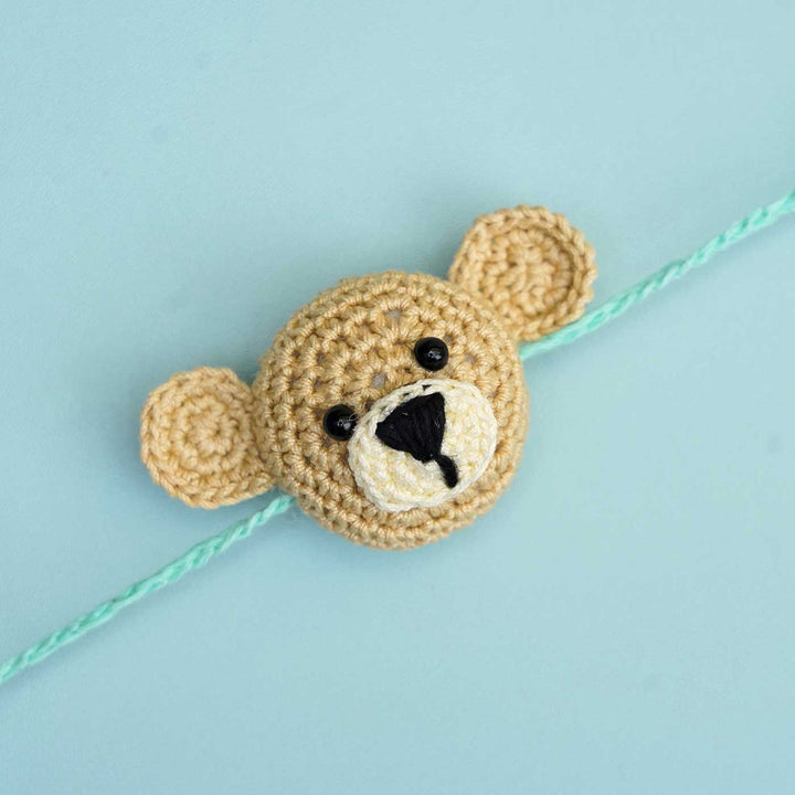 Handmade Crochet Teddy Hug Kids Rakhi With Roli Chawal - Close-up Front View with Blue Thread