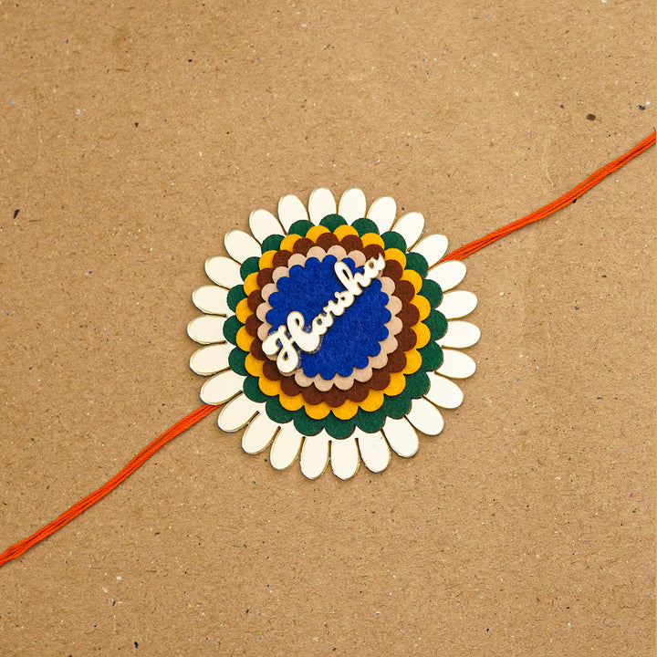 Personalized Handmade Flower Name Acrylic Rakhi With Roli Chawal - Flat lay with string extended