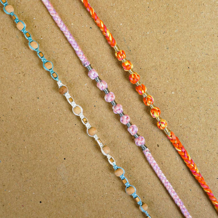 Reusable Beaded Orange Ombre Knot Rakhi With Roli Chawal - Multiple Rakhis displayed side by side