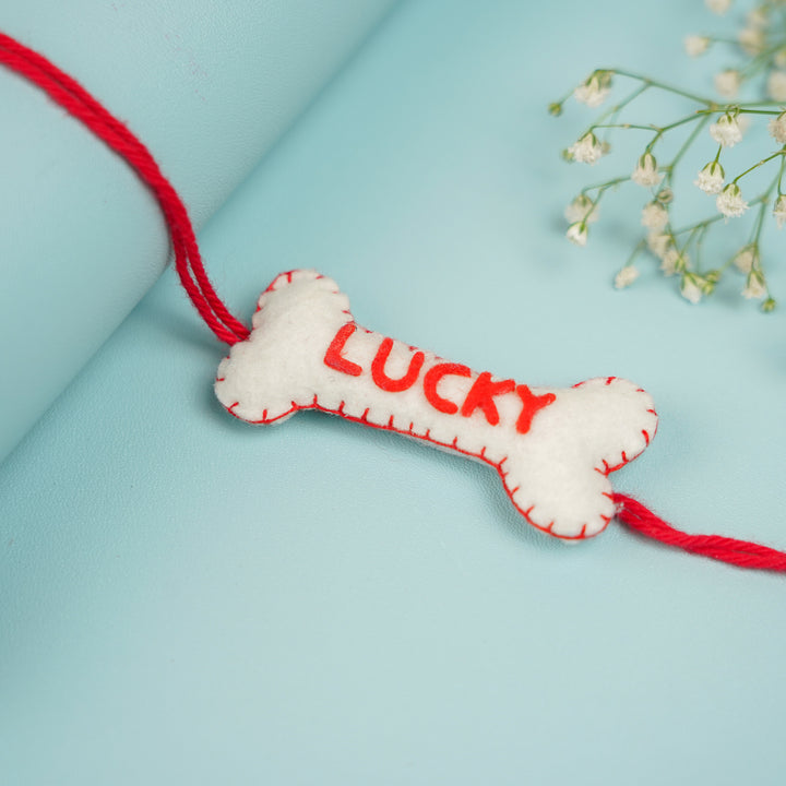 Personalized Handmade Bone Theme Felt Rakhi With Roli Chawal - Side angle of Lucky bone charm