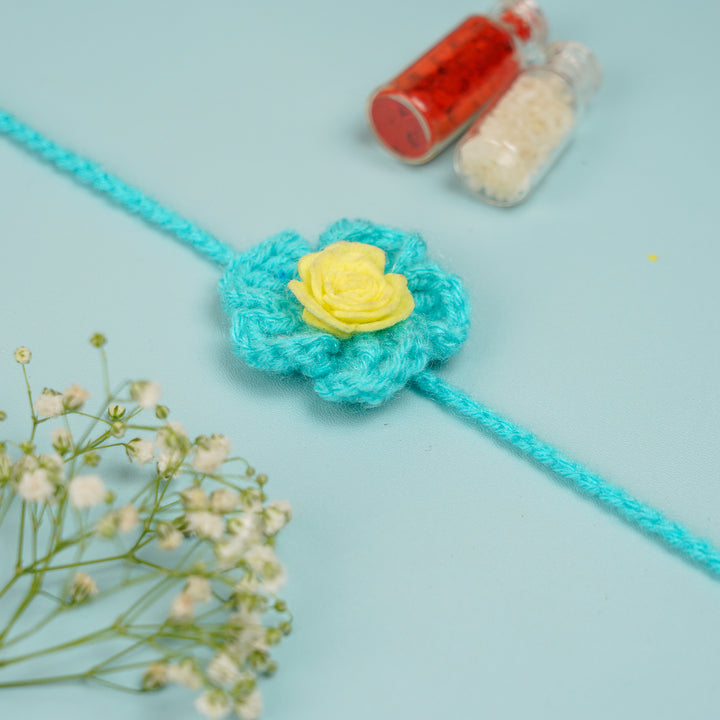 Handmade Crochet Blush Bloom Rakhi With Roli Chawal - Blue Flower Rakhi with Roli Chawal Bottles