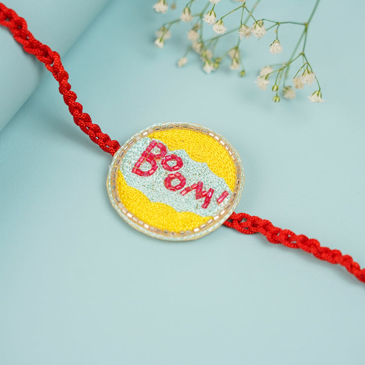 Handmade Beaded Boom Superhero Rakhi With Roli Chawal For Brother - Close-up of Embroidered Centerpiece