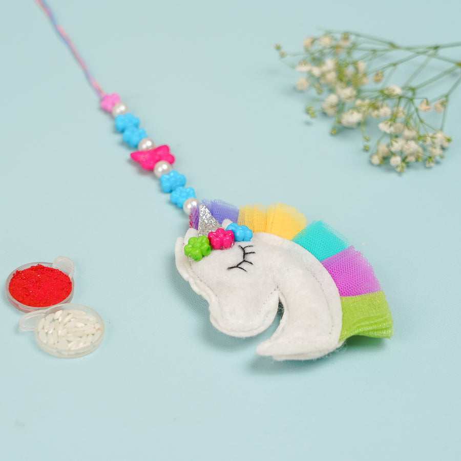 Handmade Unicorn Theme Felt Kids Lumba Rakhi For Girls With Roli Chawal - Front View with Festive Items