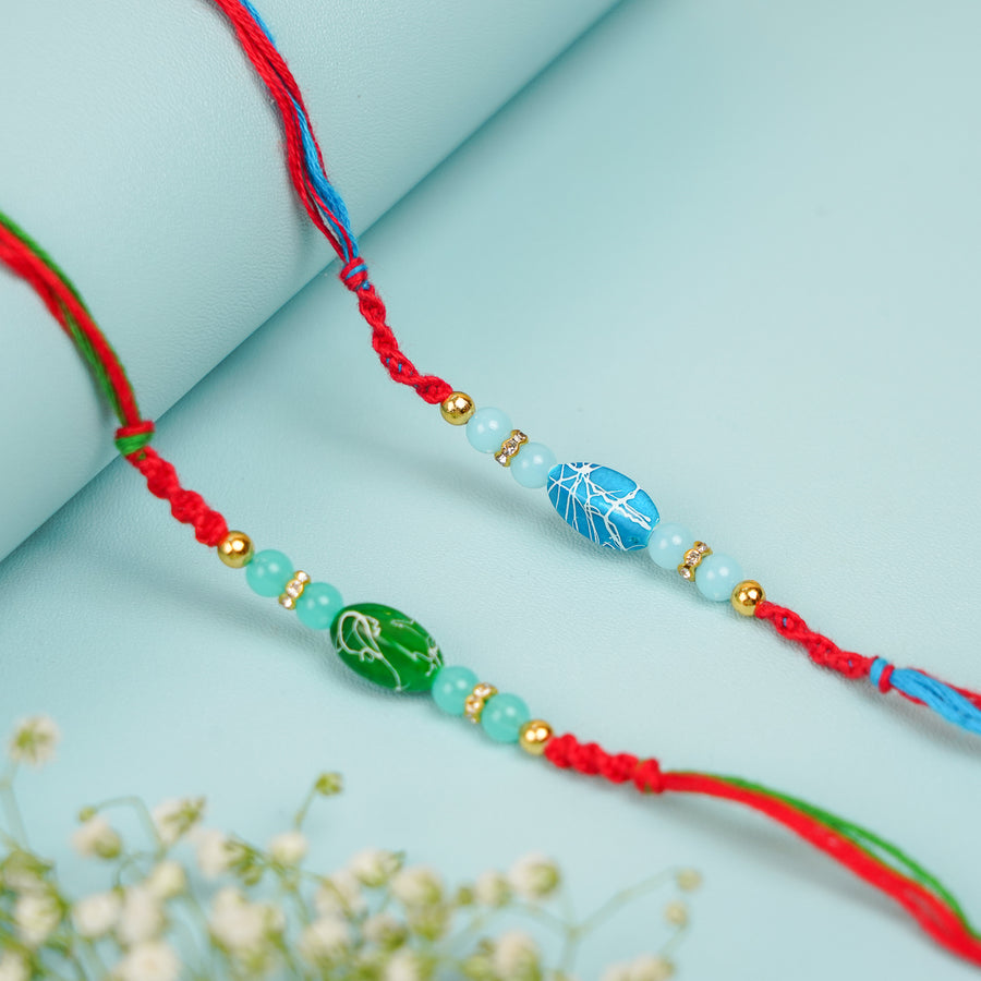 Handmade Beaded Blue And Green Stone Rakhi With Roli Chawal Set Of 2 - Pair Display with Flowers