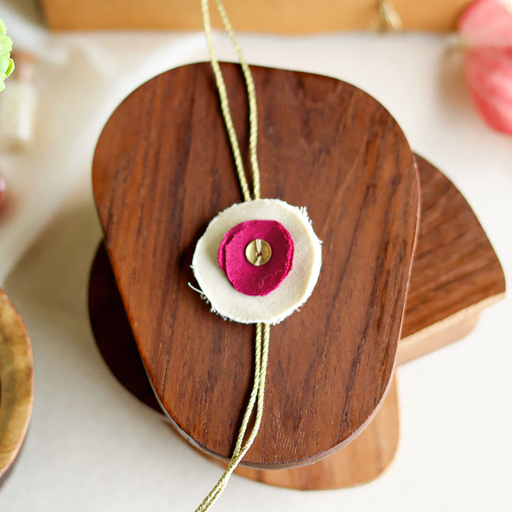 Handmade Reusable Floral And Gold Accent Upcycled Fabric Rakhi With Roli Chawal For Brother - Single flower detail on wooden spool (6)
