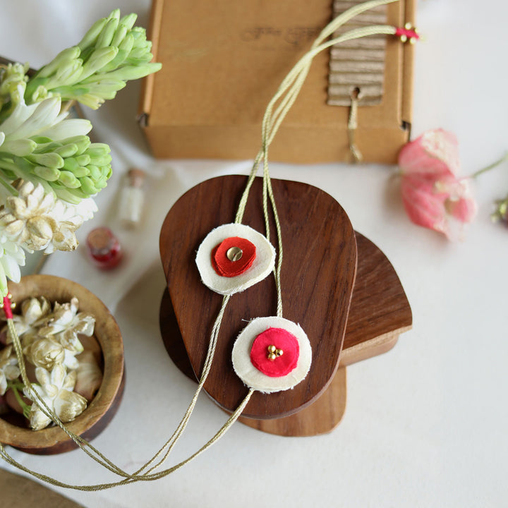 Handmade Reusable Dual Layer Upcycled Fabric Rakhi With Roli Chawal For Brother Set Of 2 - Necklace Front View with Props