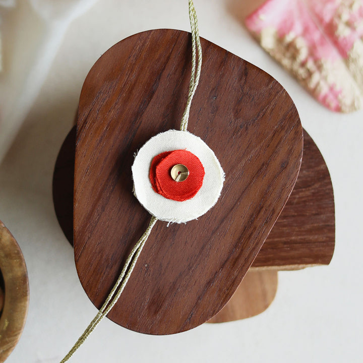 Handmade Reusable Dual Layer Upcycled Fabric Rakhi With Roli Chawal For Brother - Close-up of red and white rakhi