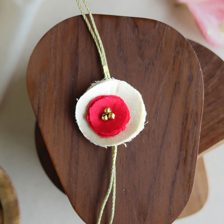 Handmade Reusable Dual Layer Upcycled Fabric Rakhi With Roli Chawal For Brother - Close-up of pink and white rakhi