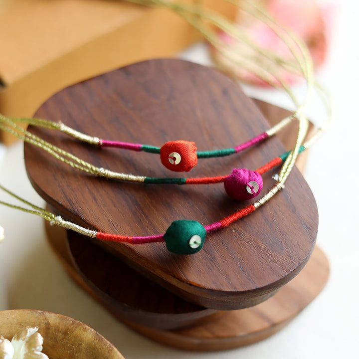 Handmade Reusable Colourful Theard Pods Upcycled Fabric Rakhi With Roli Chawal For Brother - Close-up on colorful thread details