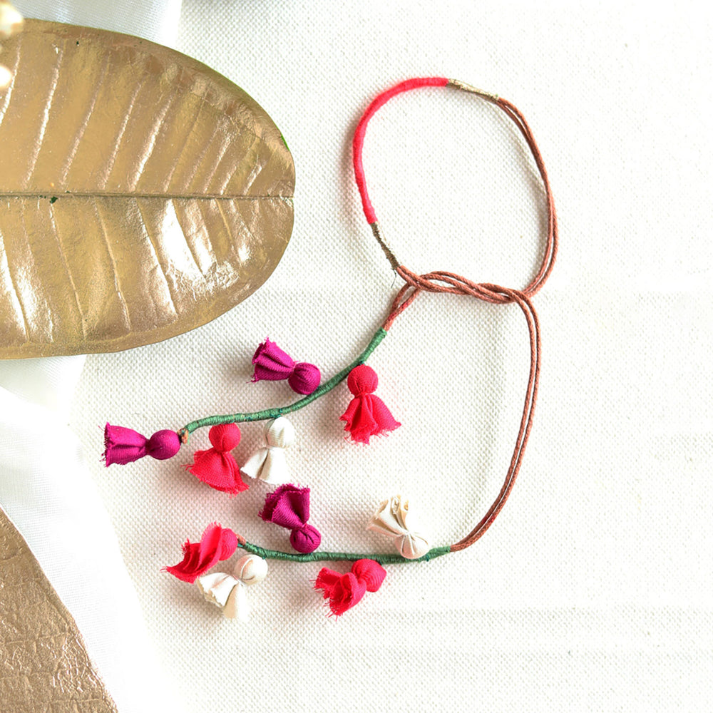 Handmade Reusable Colorful Floral Tassel Latkans Upcycled Fabric Lumba Rakhi For Bhabhi With Roli Chawal - Flat Lay with Decorative Leaves