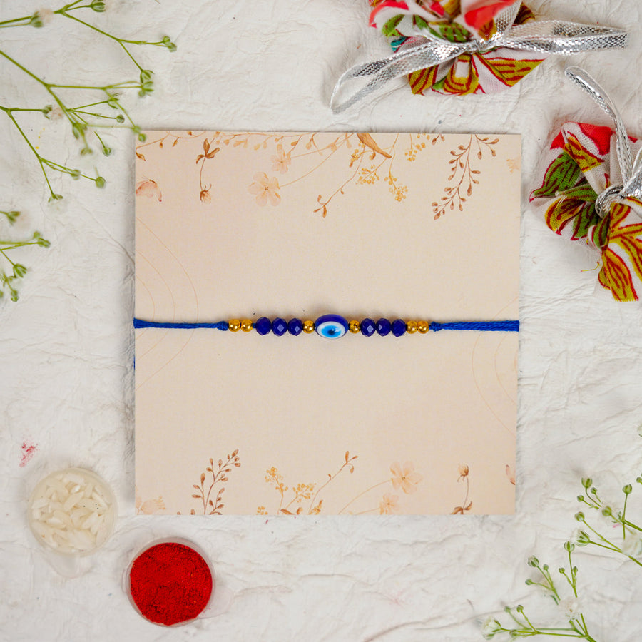 Handmade Blue Evil Eye Rakhi With Roli Chawal - Flat Lay Front View