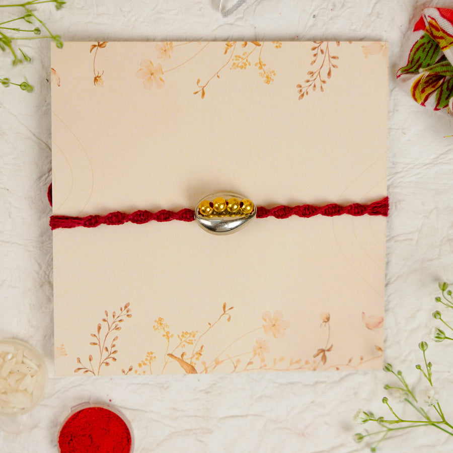 Handmade Beaded Shell Rakhi With Roli Chawal - Front View with Card Background