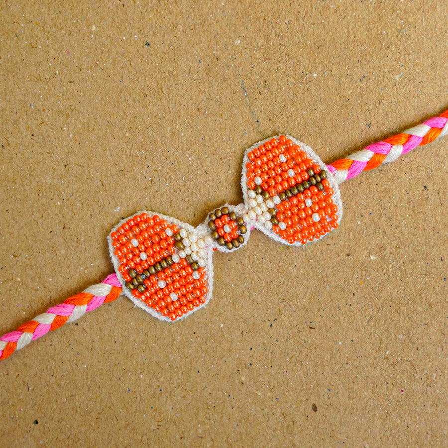 Reusable Beaded Orange Bug Rakhi With Roli Chawal - Close-up of beaded rakhi detail