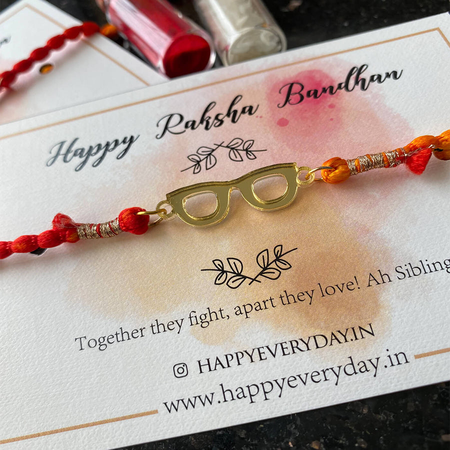 Handcrafted Golden Acrylic Rakhi With Roli Chawal 8 - Close-up of glasses charm
