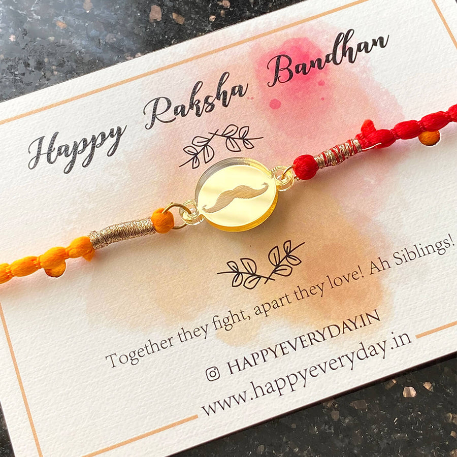 Handcrafted Golden Acrylic Rakhi With Roli Chawal 6 - Close-up on Mustache Charm