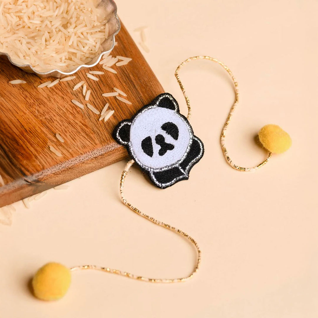 Handmade Panda Felt Kids Rakhi - Flat Lay with Rice and Props
