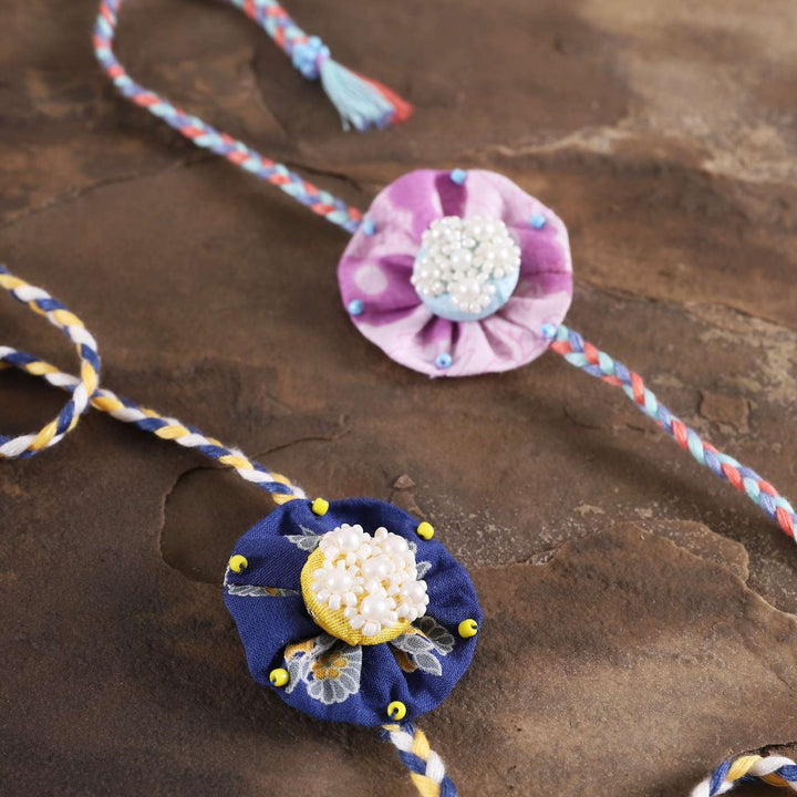 Handmade Beaded Round Pearl Rakhi With Roli Chawal Set Of 2 - Close-up of Embroidered Bracelets