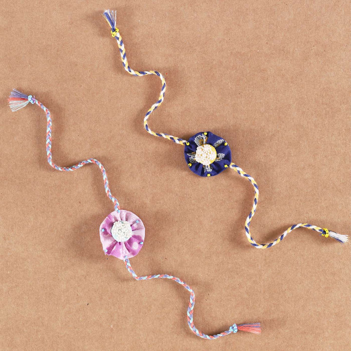Handmade Beaded Round Pearl Rakhi With Roli Chawal Set Of 2 - Flat Lay on Plain Background