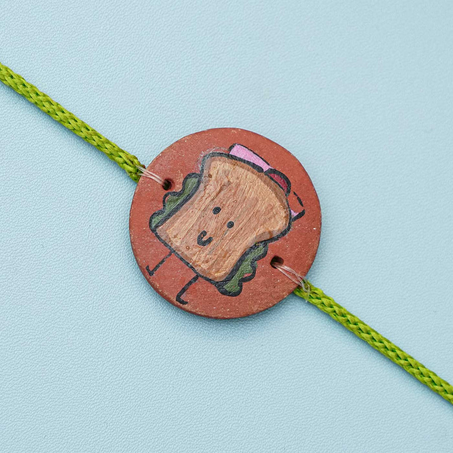 Hand Painted Sandwich Terracotta Rakhi With Roli Chawal Copy - Close-up of Rakhi Bracelet