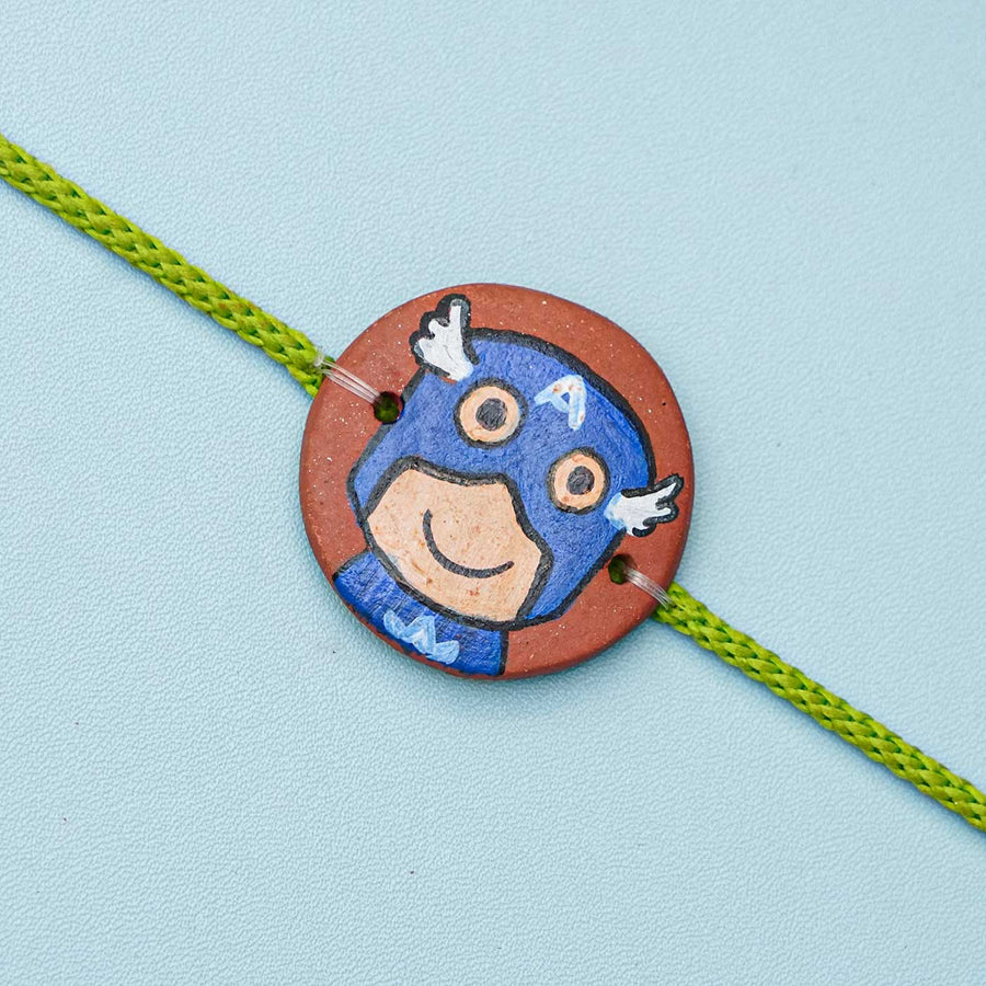 Hand Painted Captain America Terracotta Rakhi With Roli Chawal For Kids - Close-up of Bracelet Charm