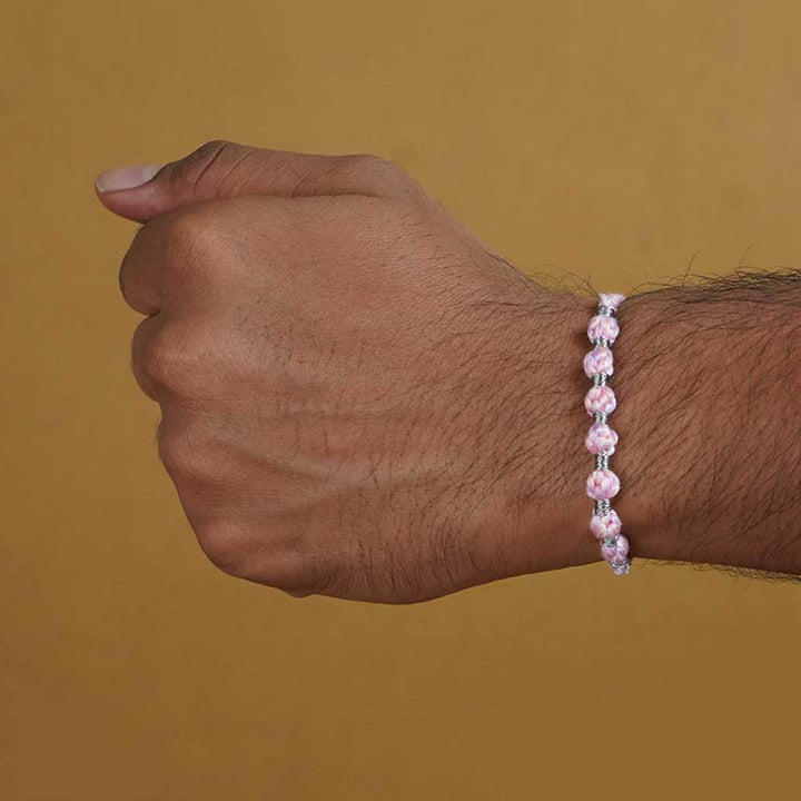 Reusable Beaded Pink Ombre Knot Rakhi With Roli Chawal - Worn on wrist close-up