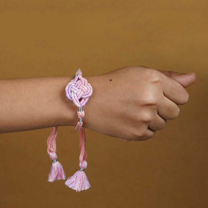 Reusable Embroidered Pink Ombre Infinity Knot Rakhi With Roli Chawal - Worn on Wrist Showing Fit
